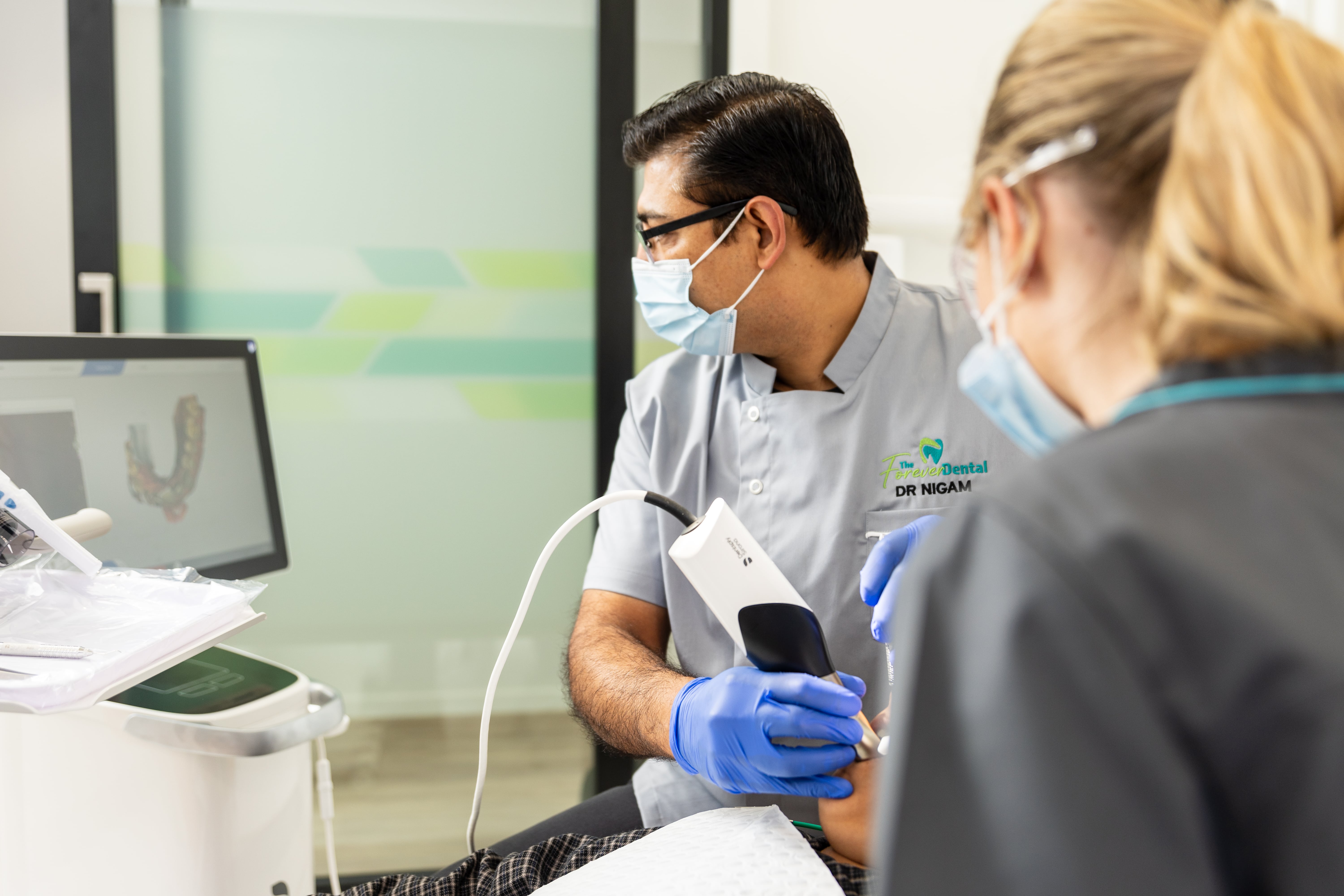 Dentist using an intraoral camera to show detailed images of teeth during a dental consultation