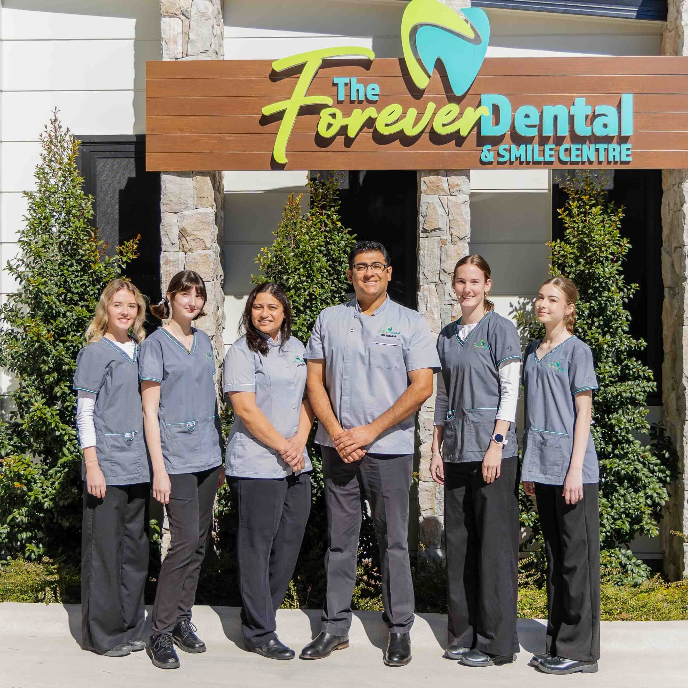 Forever Dental & Smile Centre team standing outside the dental clinic in front of the practice signage.