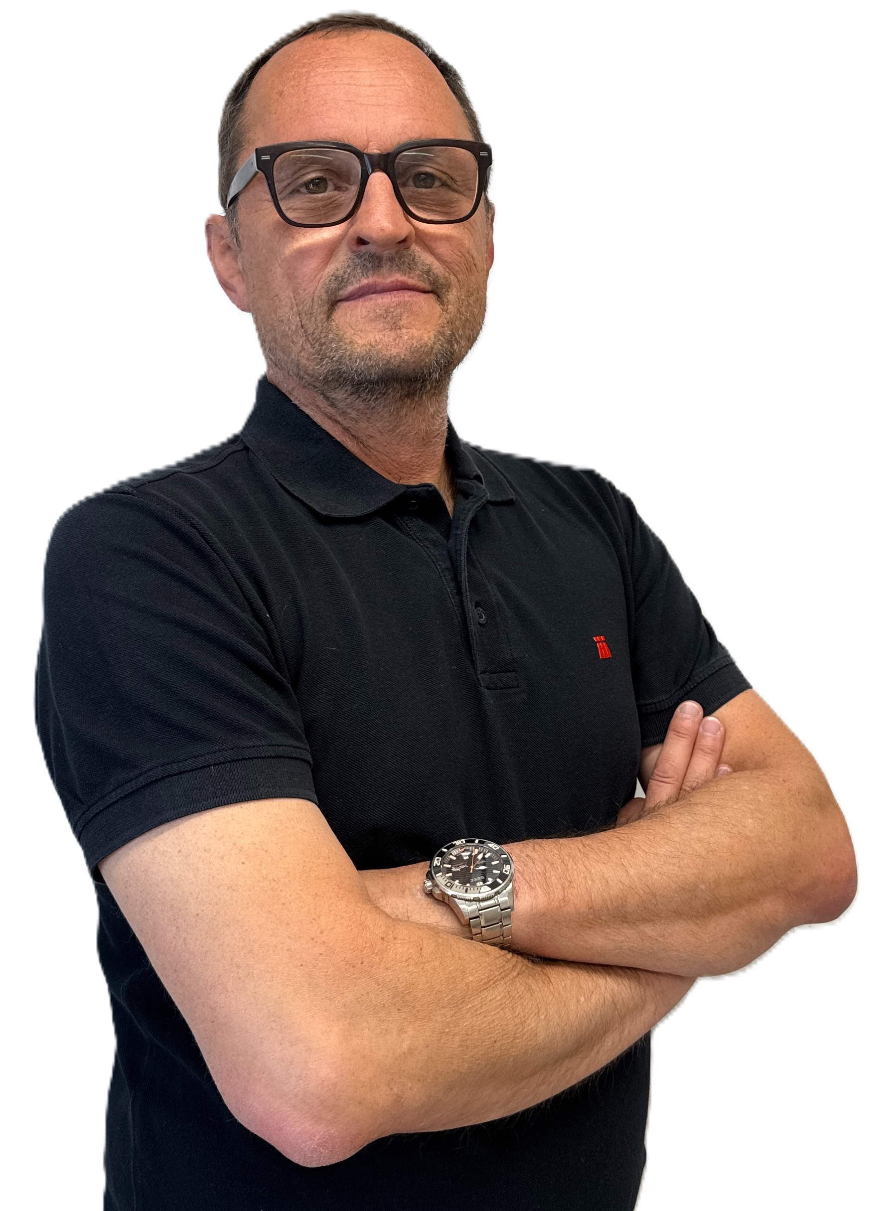 Man with glasses and a short beard wearing a black polo shirt with folded arms, standing against a plain light background.