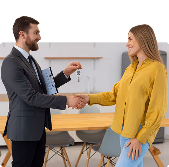 Realtor and client shaking hands with a key