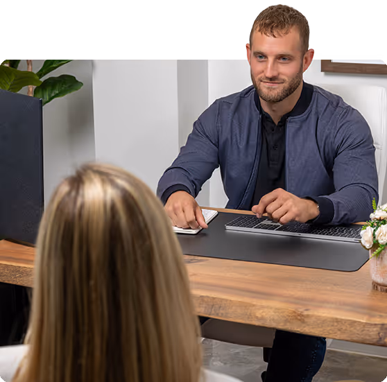 Professional meeting with man working on laptop across from client