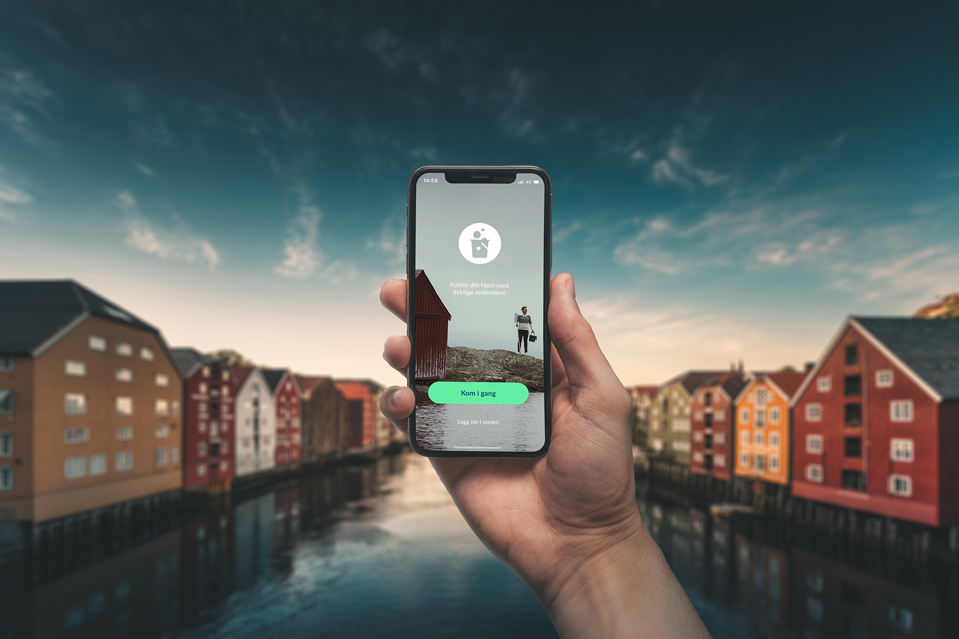 Hand holding Vaskehjelp app on mobile with beautiful scenery from Trondheim.