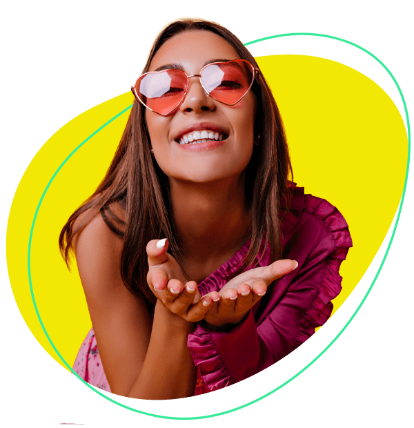 An image of a woman smiling with two oranges over her yes