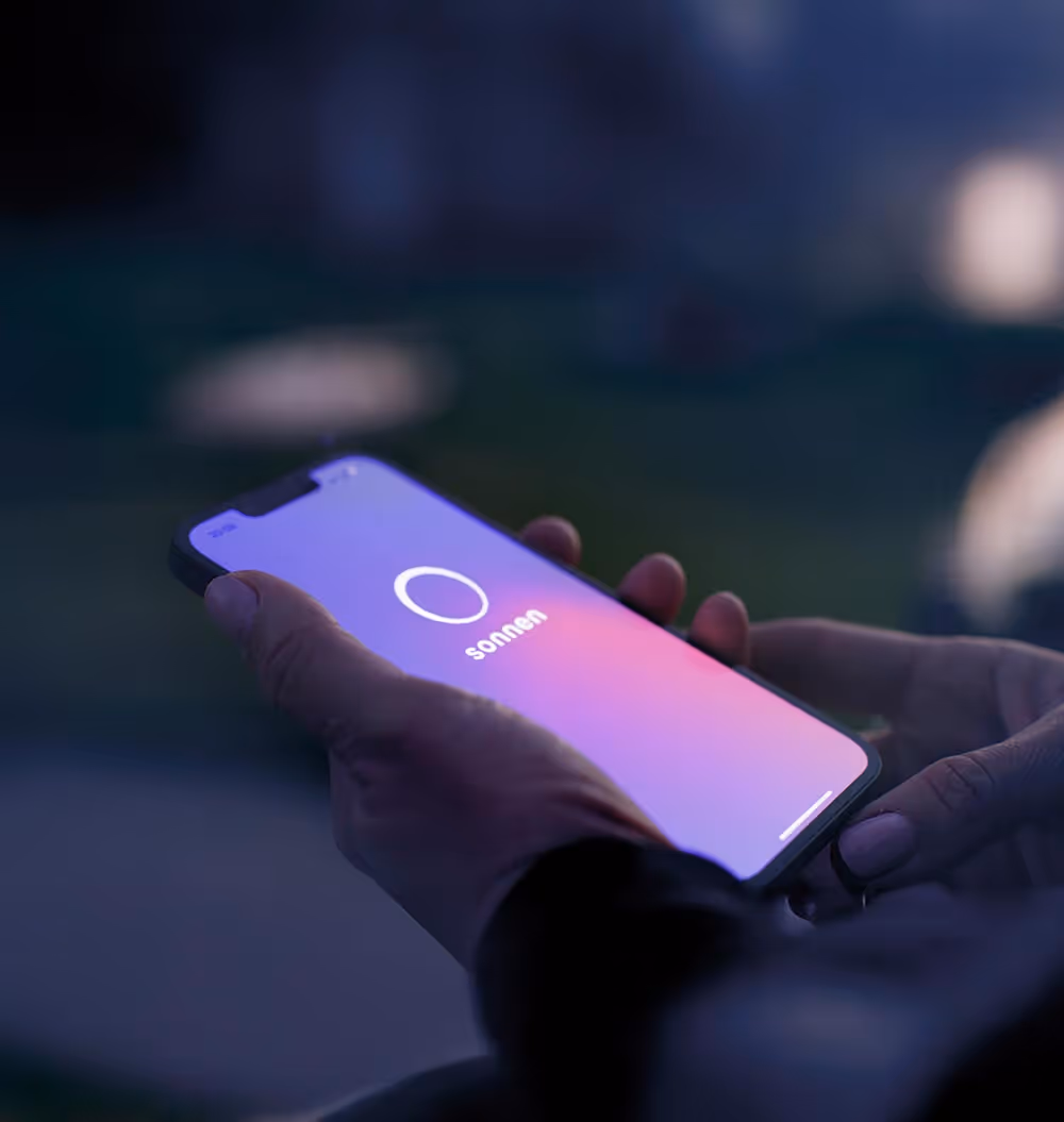 Hand hält Smartphone mit sonnen App.