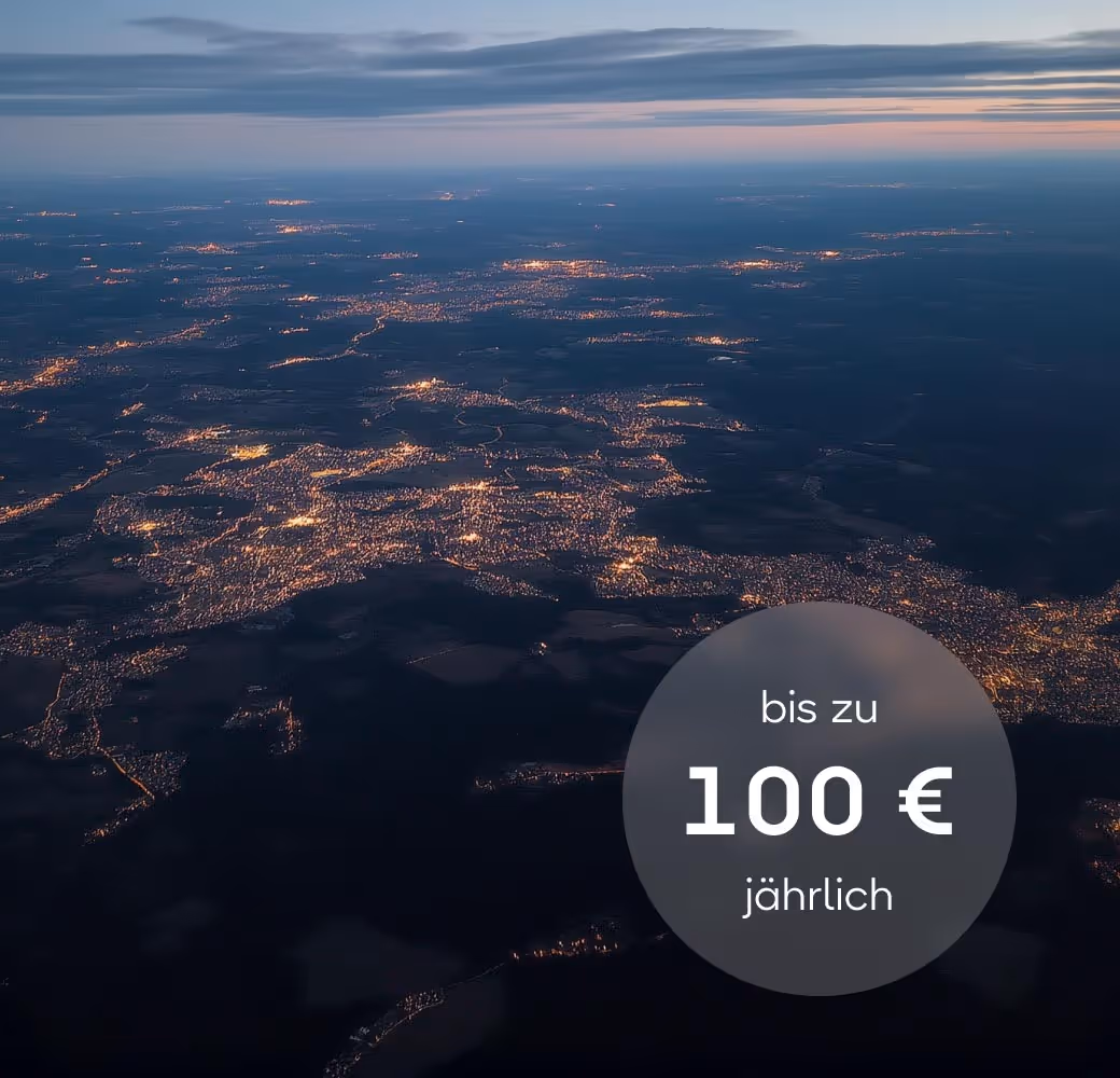 Luftaufnahme einer Landschaft bei Dämmerung mit zahlreichen beleuchteten Städten und Siedlungen.