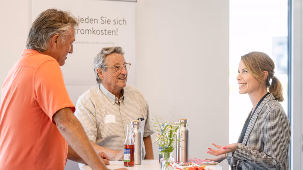 Mitarbeiterin von sonnen im Gespräch mit zwei Botschaftern.