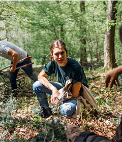 Person sammelt Tannenzweige im Wald – nachhaltige Ernte für Tannenliebe Produkte