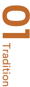 Das Wort ‚Tradition‘ vertikal in brauner Schrift auf weißem Hintergrund.
