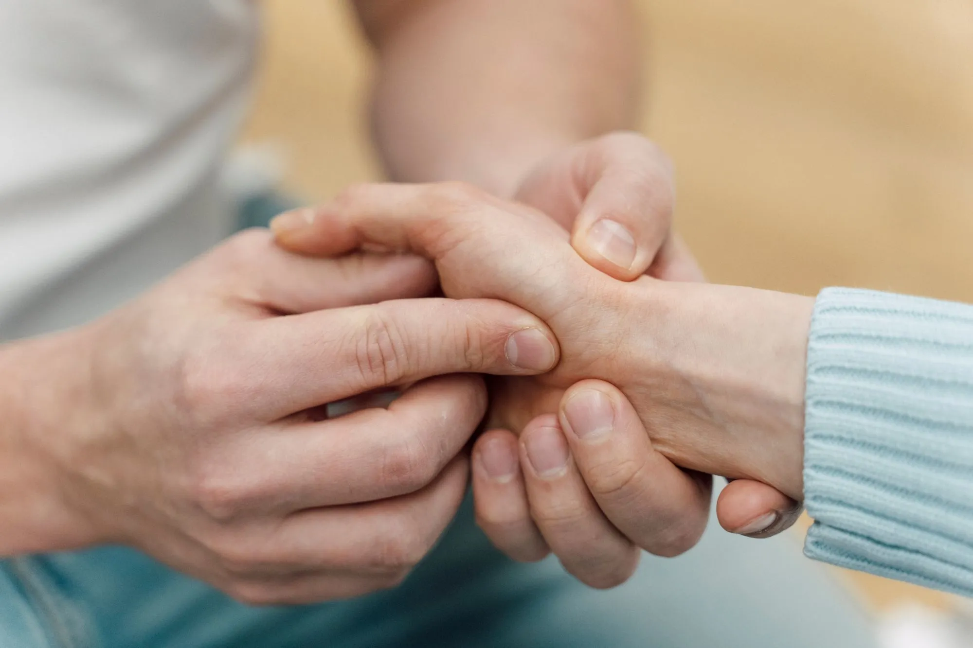 Ärztliche Behandlung an der Hand eines Patienten in einer orthopädischen Praxis.