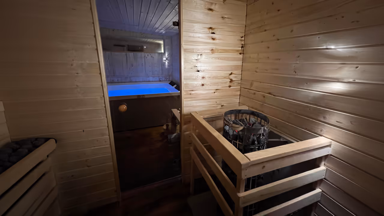 Kompakter Spa-Innenraum mit Sauna, Whirlpool und Sitzbereich.