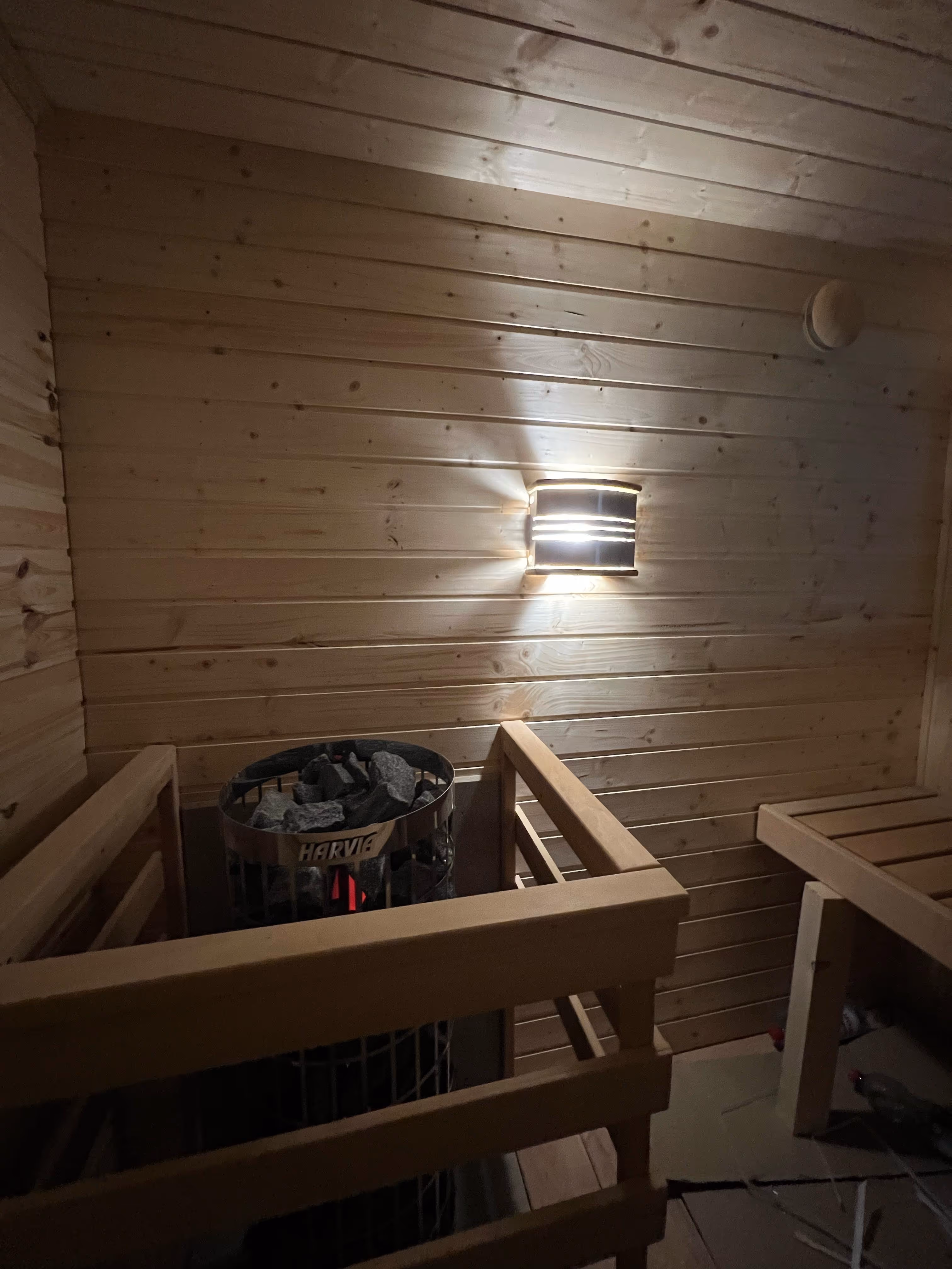 Saunastein und Holzbank im mobilen Wellness Cube.