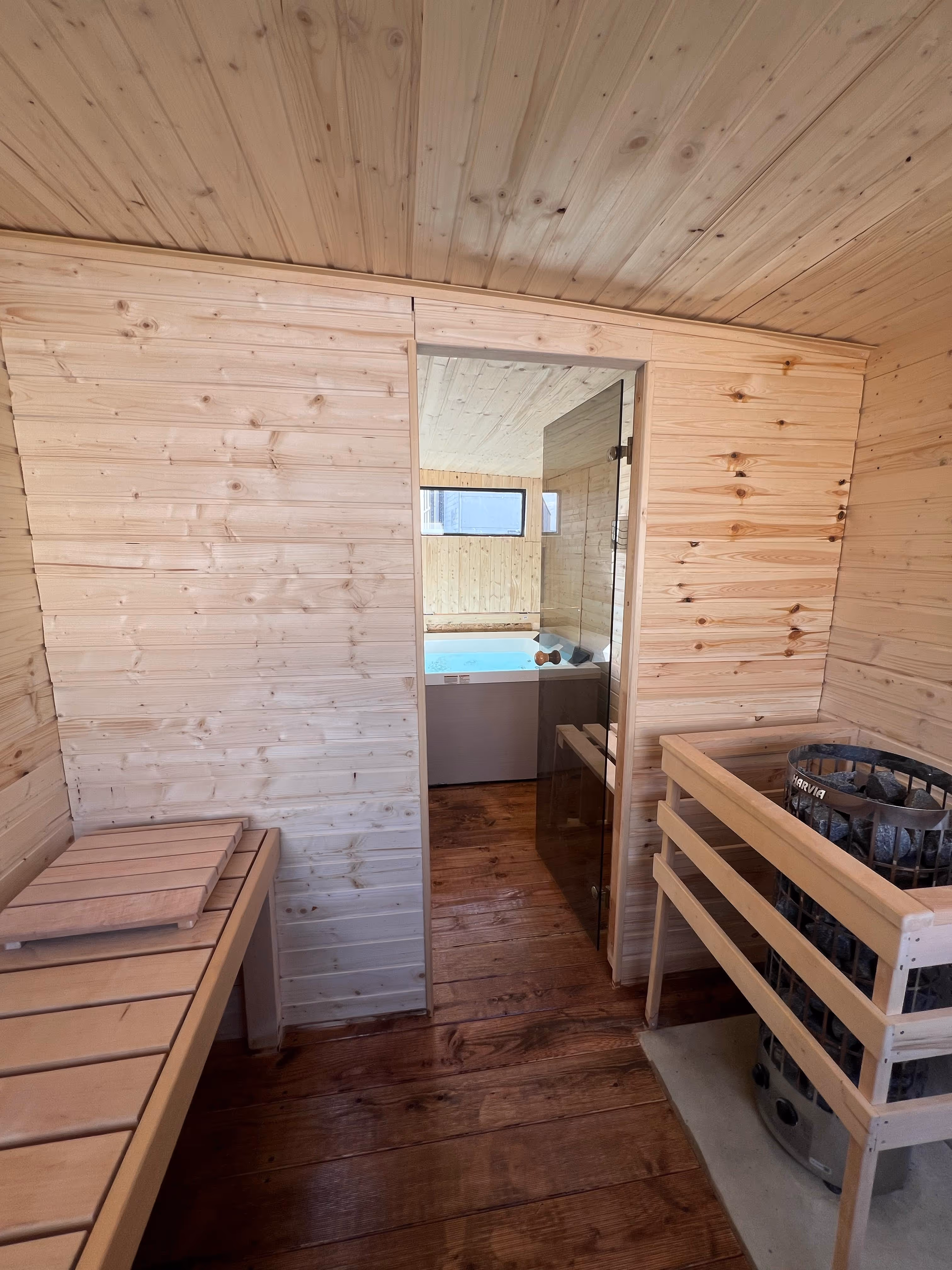 Innenansicht des Wellness Cube mit Holzverkleidung, Whirlpool und Sauna.