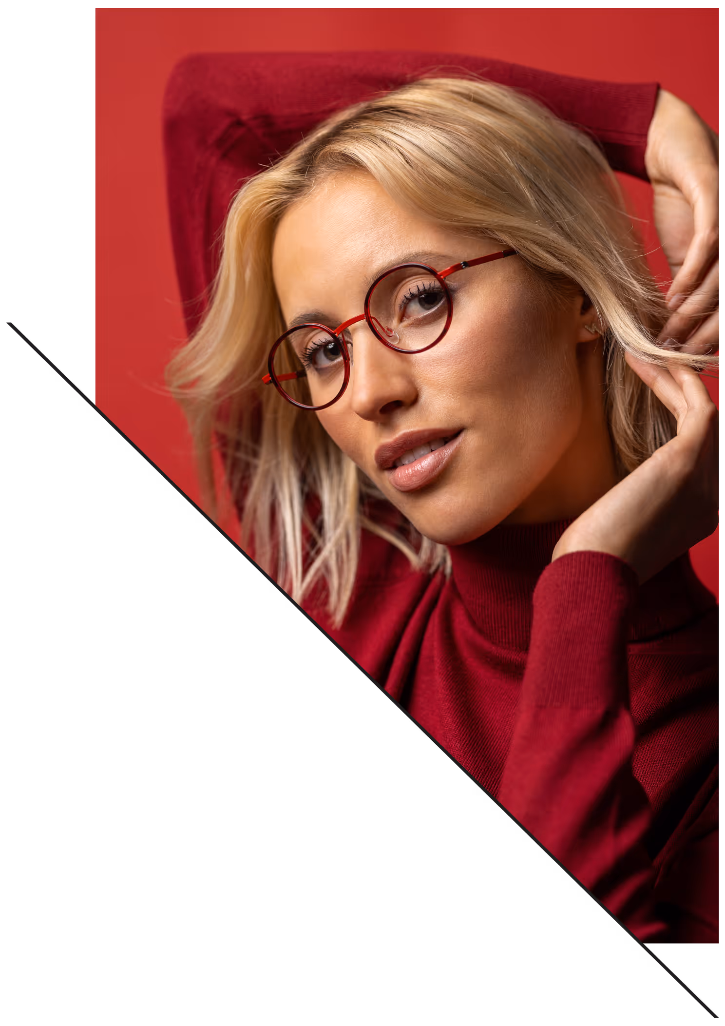 Ein blondes Model posiert vor einem roten Hintergrund und trägt eine farblich abgestimmte Brille von Feinleicht.