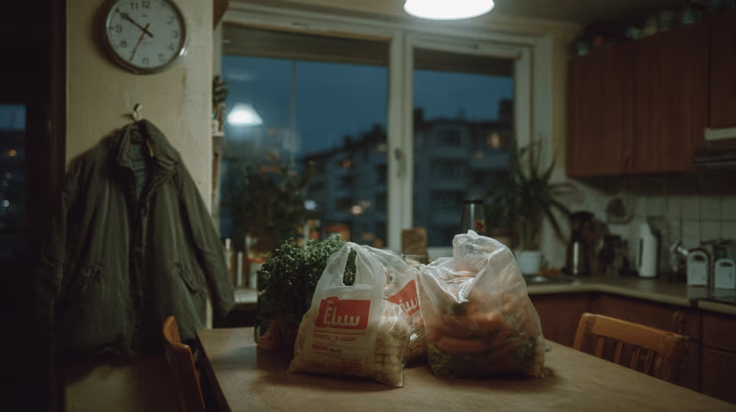 Küche bei Nacht mit Tüten voller Lebensmittel und frischen Kräutern auf einem Tisch.