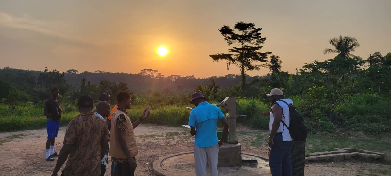 Community members in Liberia collecting clean water at sunset as part of Kijani Group’s WASH initiative.
