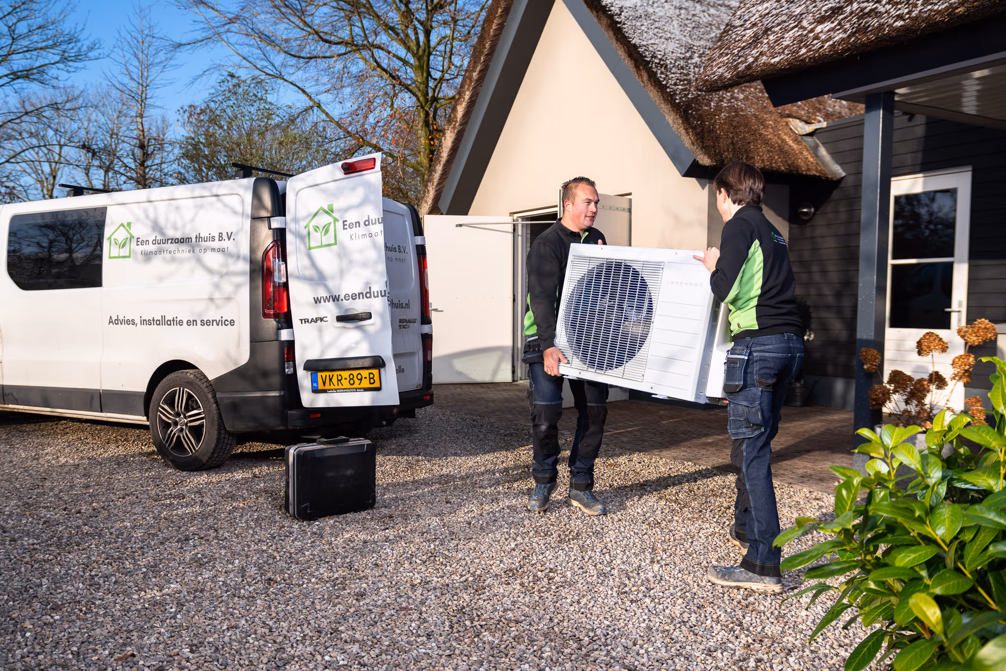 Jeroen en Niels tillen een warmtepomp klaar voor installatie in Zwolle uit de werkbus