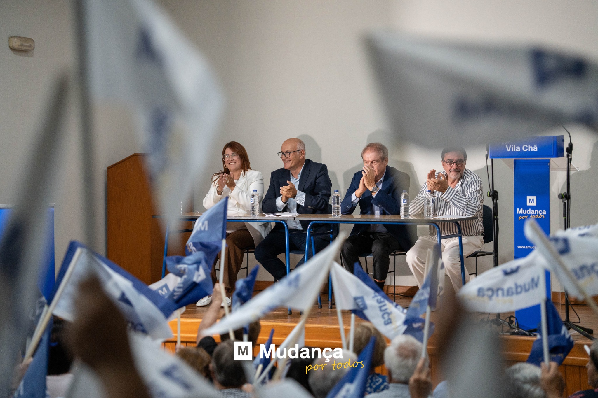 Pode ser uma imagem de 4 pessoas, multidão e a texto que diz "VilaChă VilaChă Chă Vila M Mudanca por portores M mondrwade @วทสน M Mudanga portodos por todos Mudança"