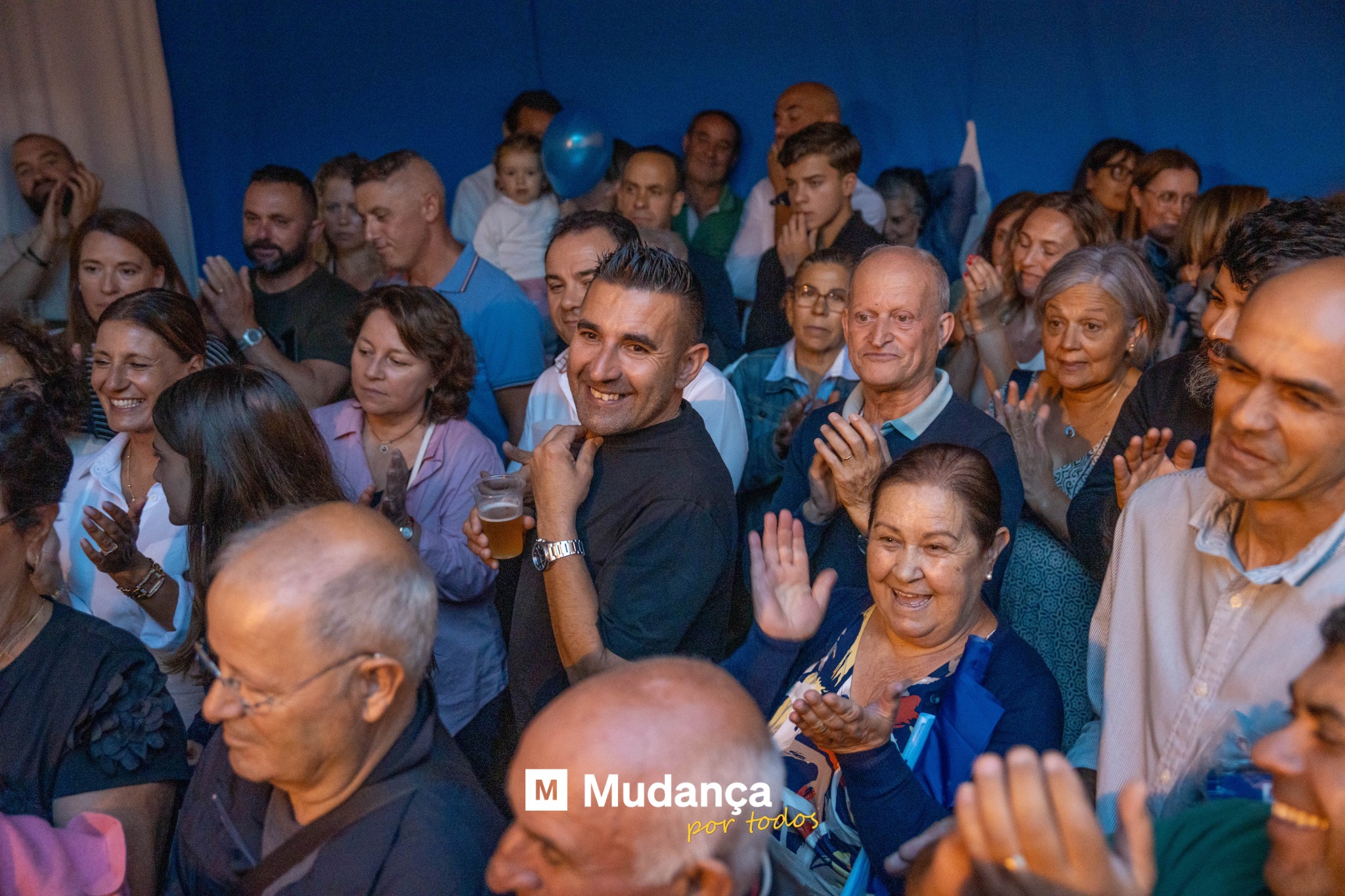 Pode ser uma imagem de 7 pessoas, multidão e a texto que diz "M Mudança por portodos todos"