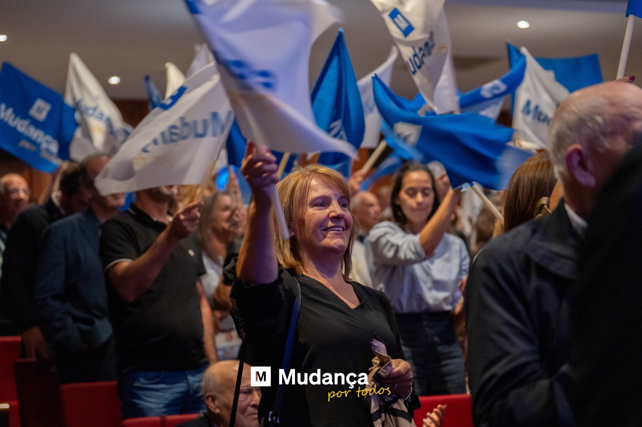 Pode ser uma imagem de 6 pessoas, multidão e a texto que diz "မက် طء M Mudança portodos por todos"