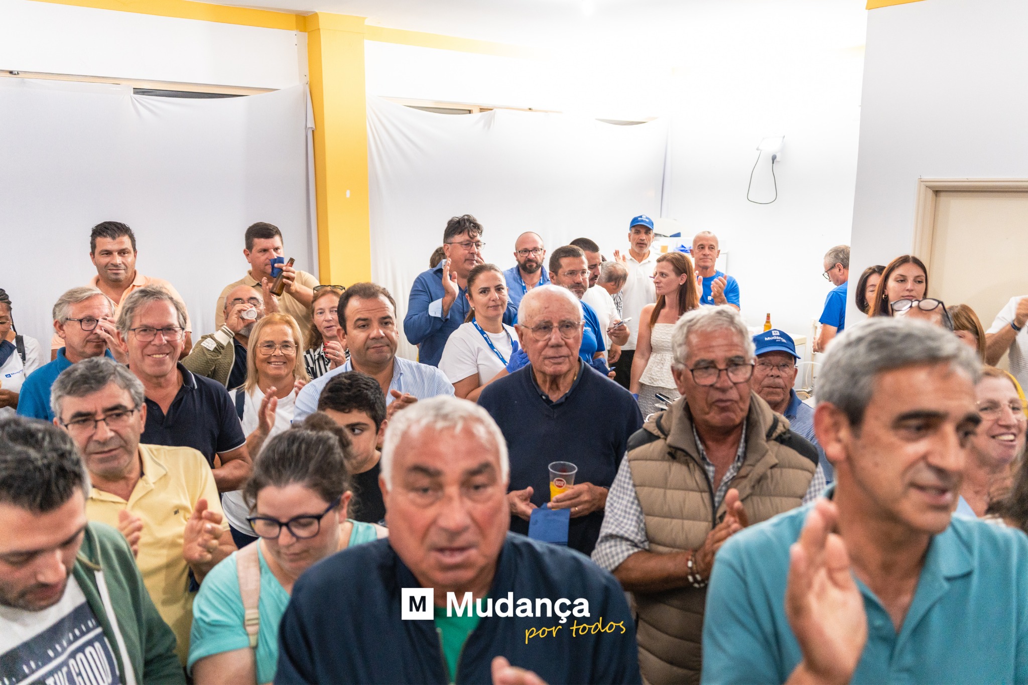 Pode ser uma imagem de 3 pessoas, multidão e a texto que diz "M Mudança por portodos todos"