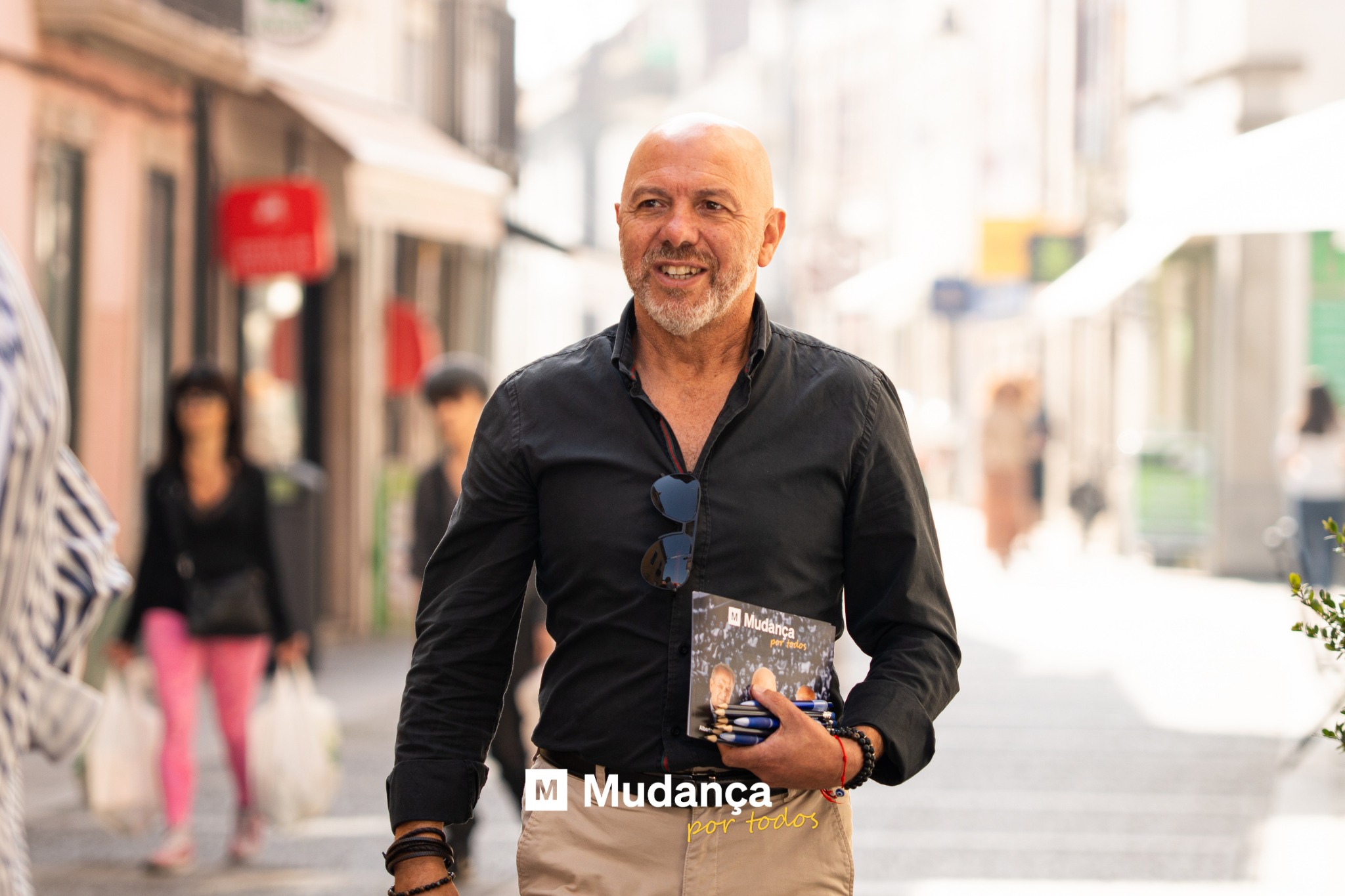 Pode ser uma imagem de 3 pessoas, barba, banca de jornais, rua e a texto que diz "M Mudança portodos ممد todos"