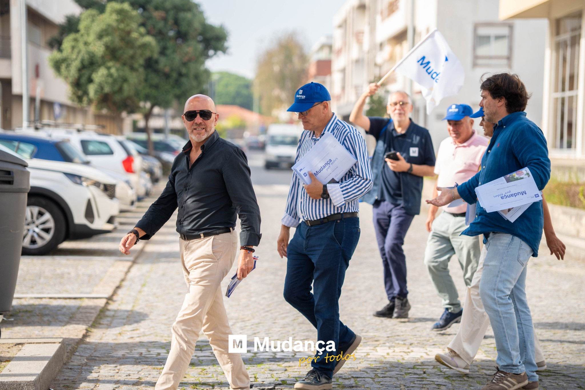 Pode ser uma imagem de 4 pessoas, rua e a texto que diz "Mude Mud. ผ Mudoen Mudança unNe g M Mudança Mud ança por todo"