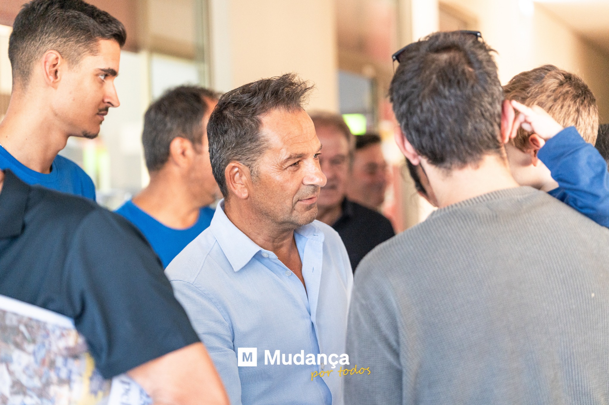 Pode ser uma imagem de 4 pessoas, pessoas a estudar, multidão e a texto que diz "M Mudança portodos por todos"