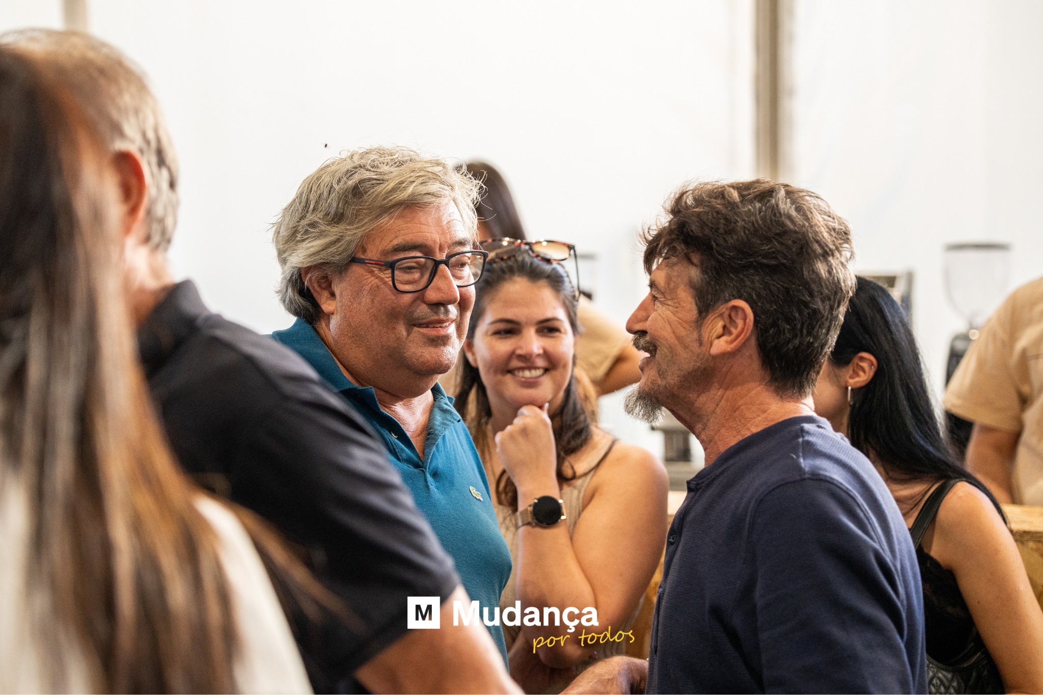 Pode ser uma imagem de 4 pessoas, multidão e a texto que diz "M Mudança portodos por todos"