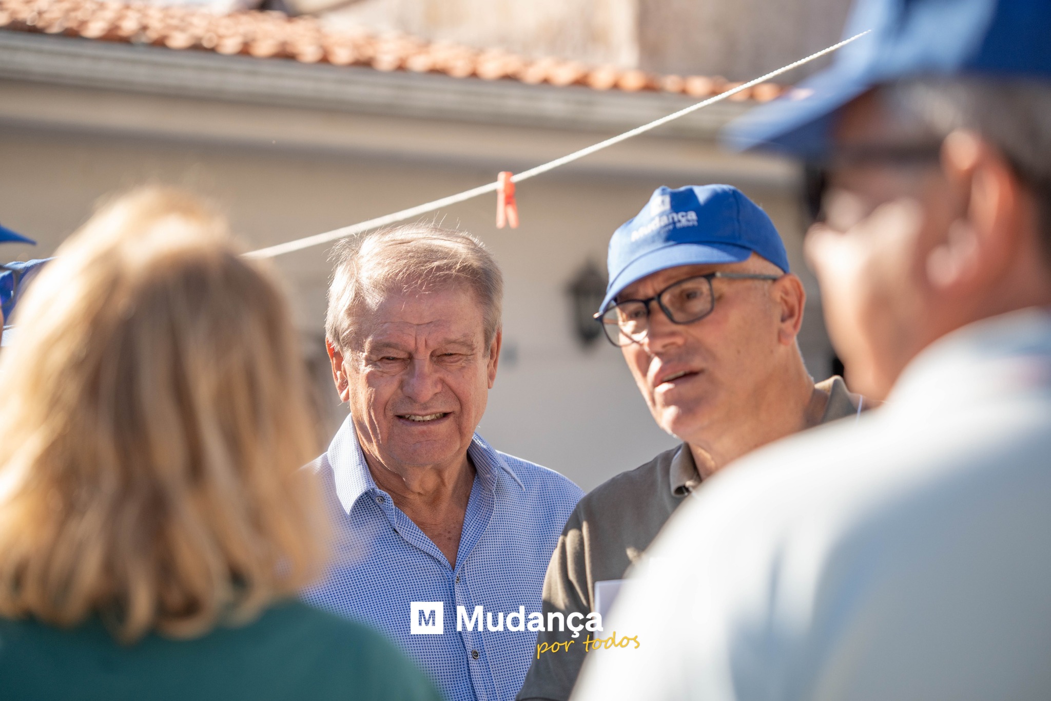 Pode ser uma imagem de 3 pessoas, multidão e a texto que diz "nςR M Mudança portodos حمد todos"