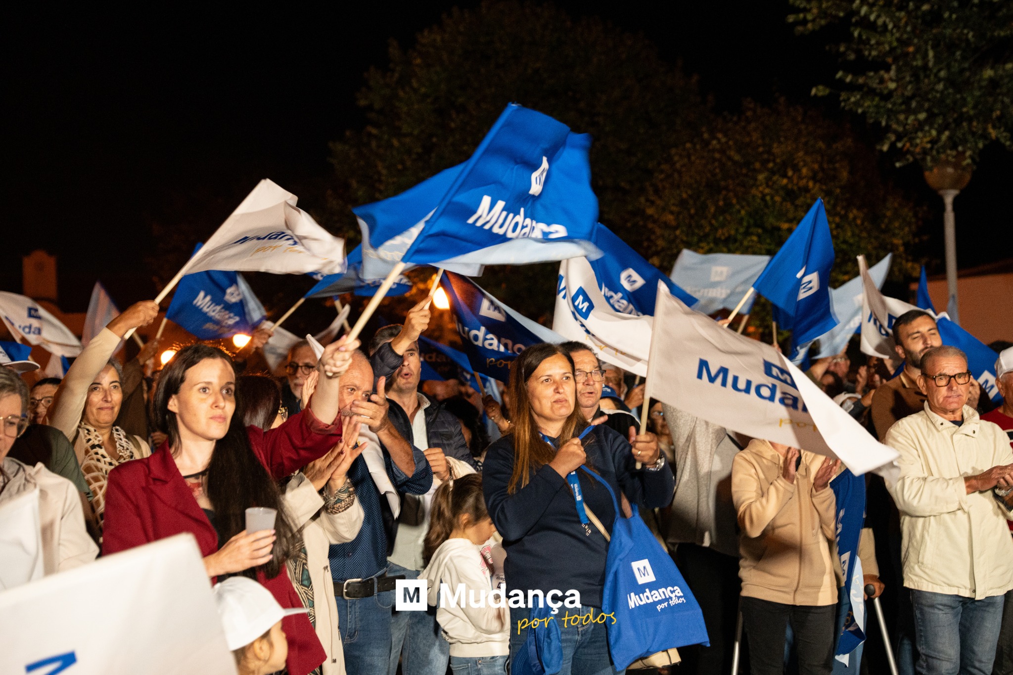 Pode ser uma imagem de 6 pessoas, multidão e a texto que diz "da Muda Mudara M M vian da Mud MUMudança M Mudança ydos por portodos por todos"