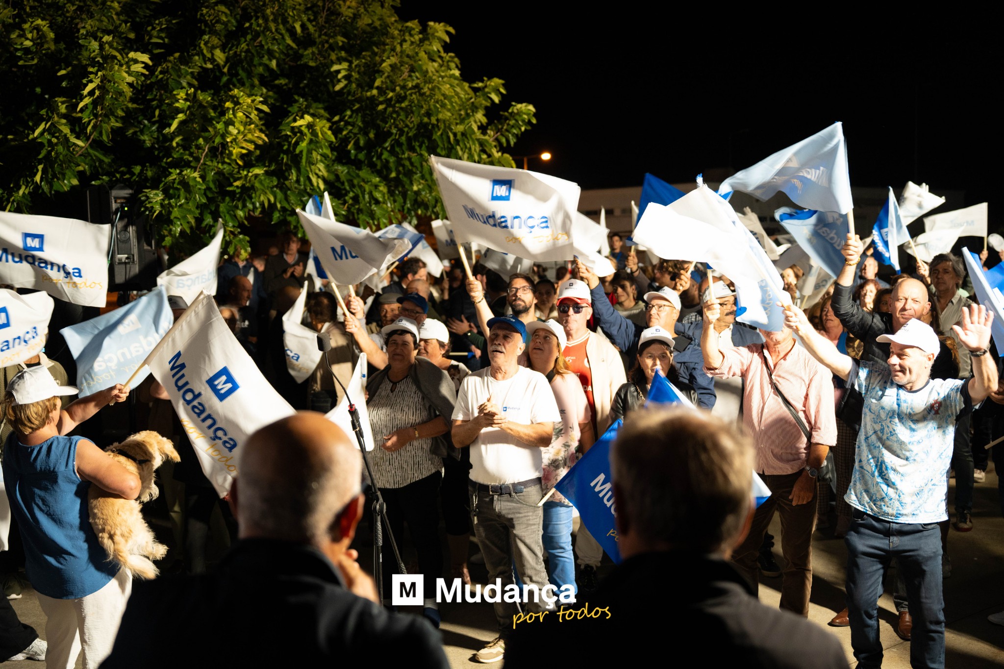 Pode ser uma imagem de 3 pessoas, multidão e a texto que diz "M anga ורזב Belos -Qy! Mudanca anca anca M M Mudança por portodos todos"