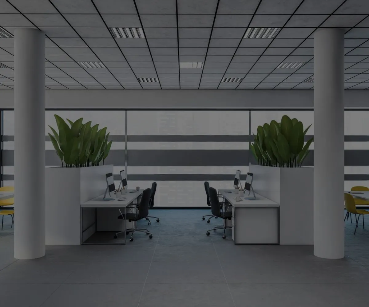 Bureau open space moderne avec postes de travail et grandes plantes vertes en île-de-France