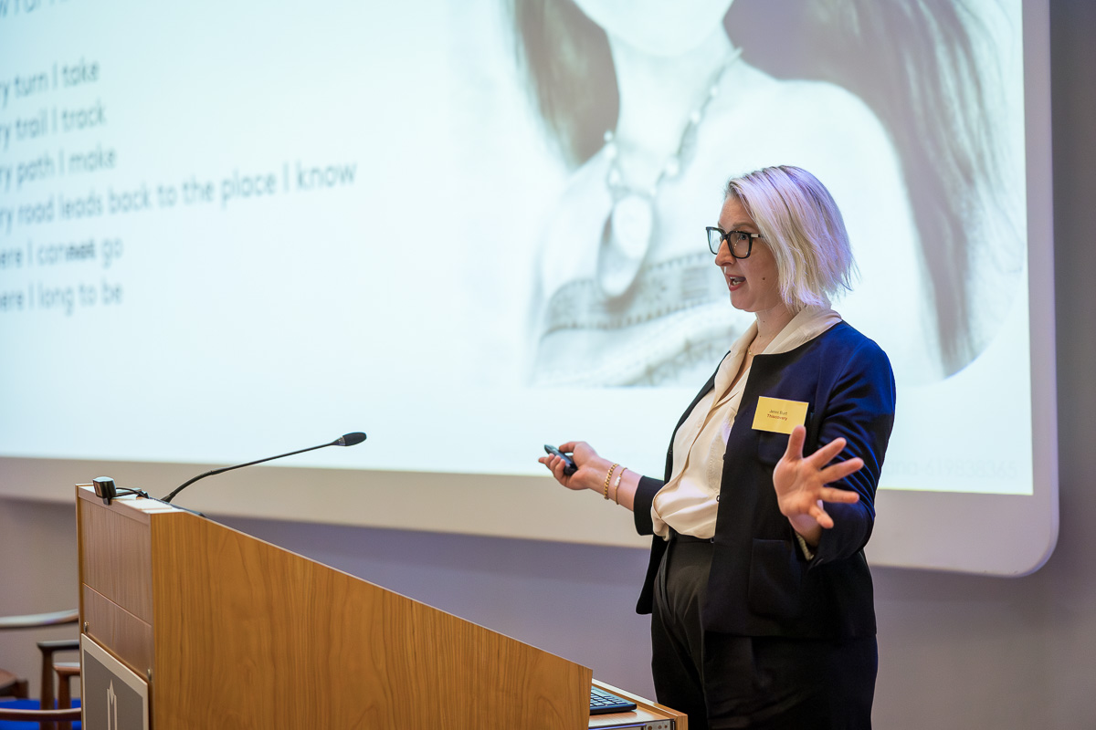 Jenni Burt, Thiscovery's Chief Scientific & Innovation Officer, presenting to an audience in front of a projected presentation. 