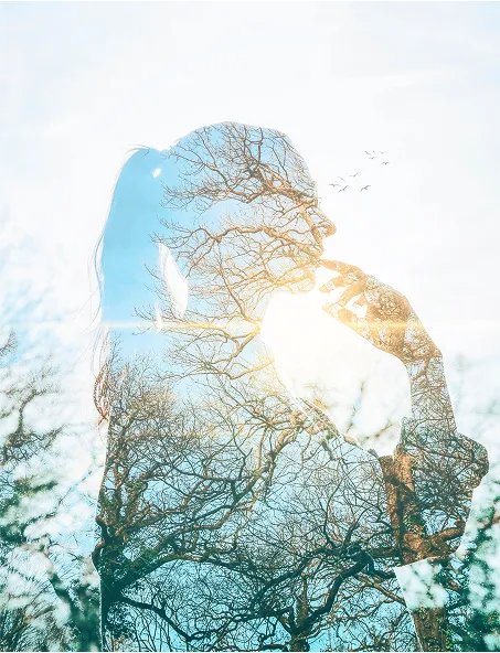 Silhouette féminine en double exposition avec des arbres, symbolisant l'harmonie intérieure et les soins énergétiques