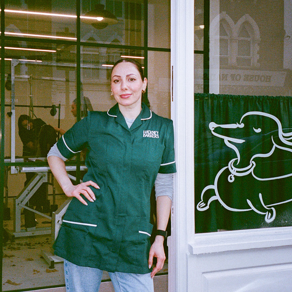 Jade, founder of Hackney Barkers, standing at the salon door on Chatsworth Road, Hackney