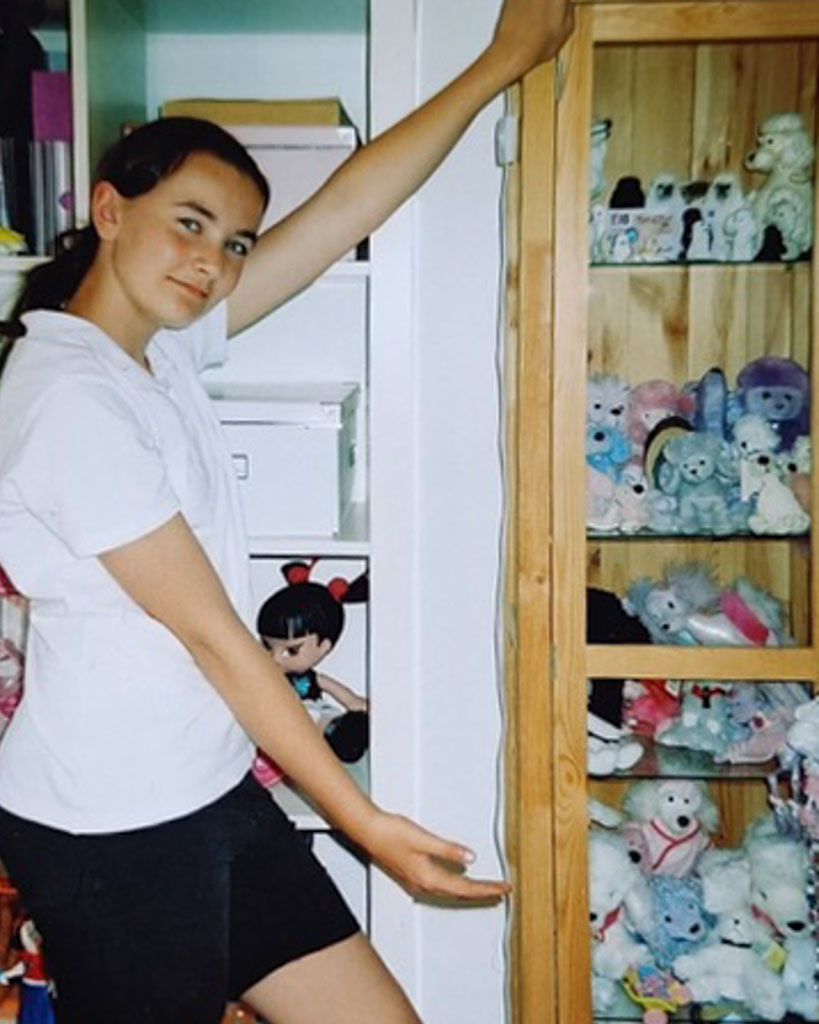 Keeley as a child showing her cupboard full of dog toys