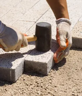 Darbuotojas kloja trinkeles aikštėje
