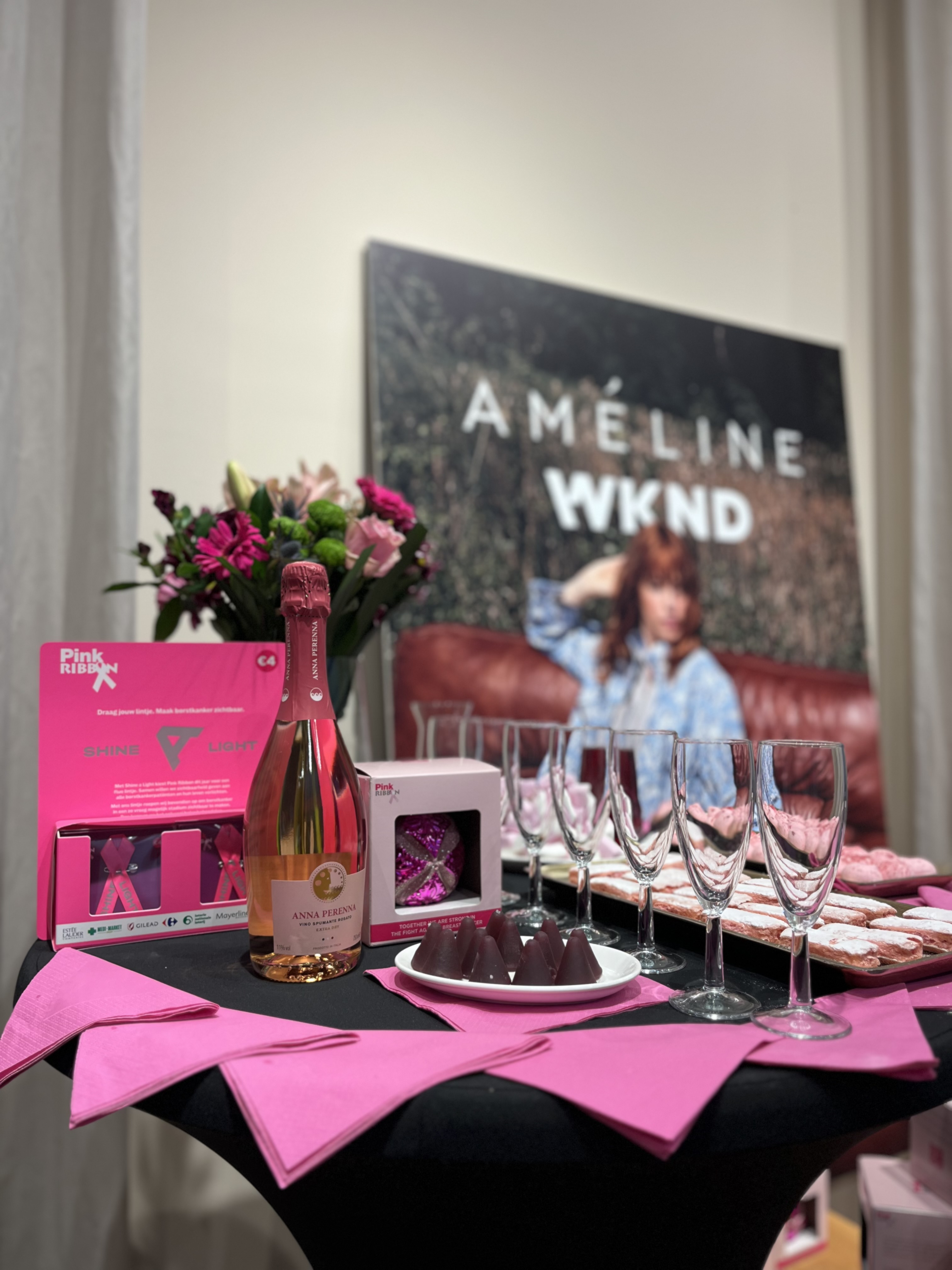 Partytafel met roze servietten, roze bubbels en Pink Ribbon lintjes.