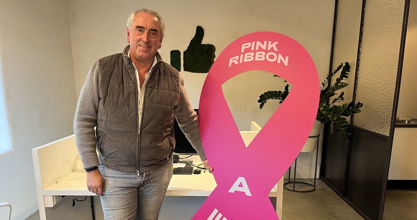 Aimé Van Hecke poseert met een grote versie van het Pink Ribbon Shine A Light lintje 2025.