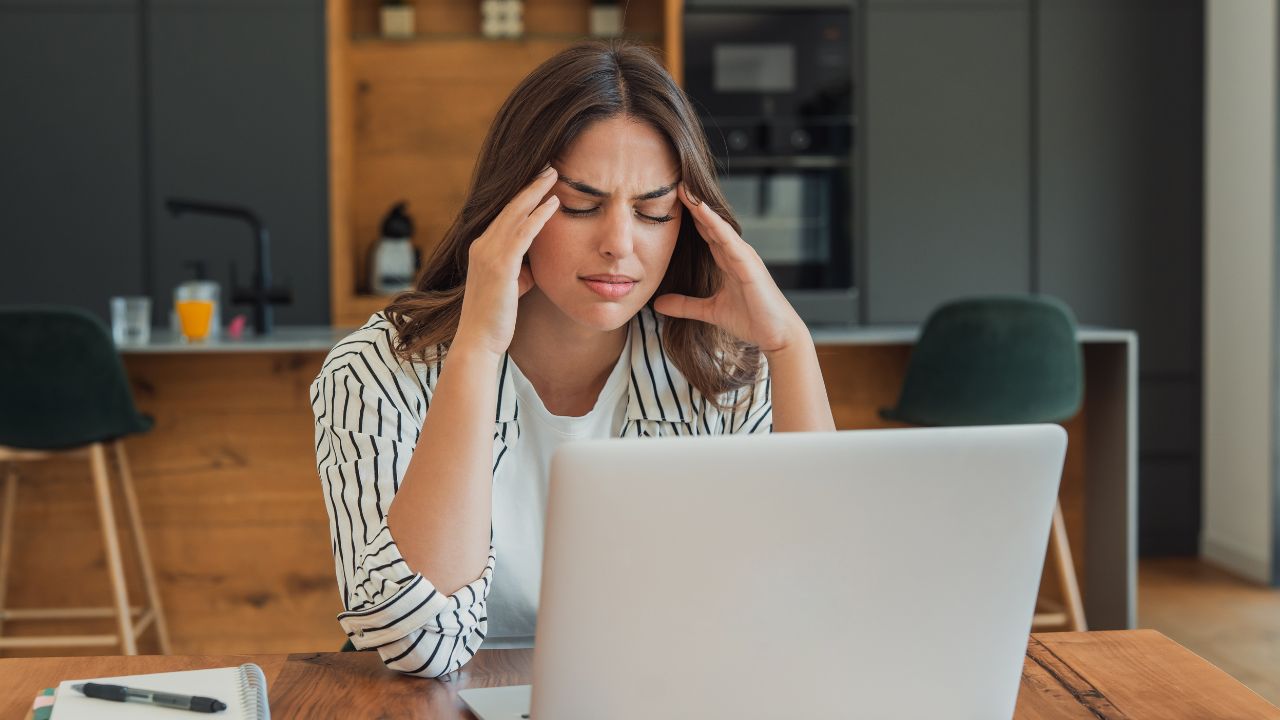 Vrouw met neverwerkingen achter een laptop
