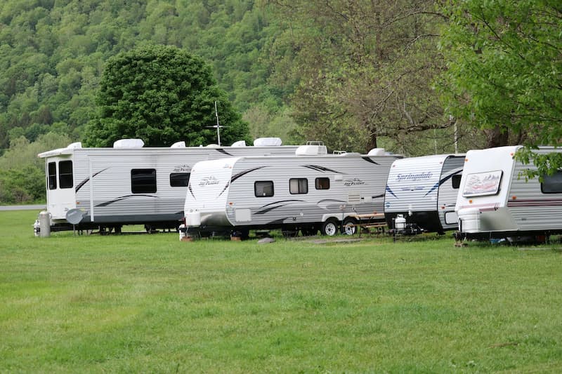 recreational trailers parked and hooked up to water at campsite