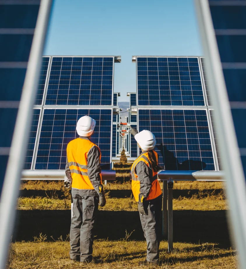 Two solar technicians inspecting a panel on an Indiana farm during agricultural solar installation
