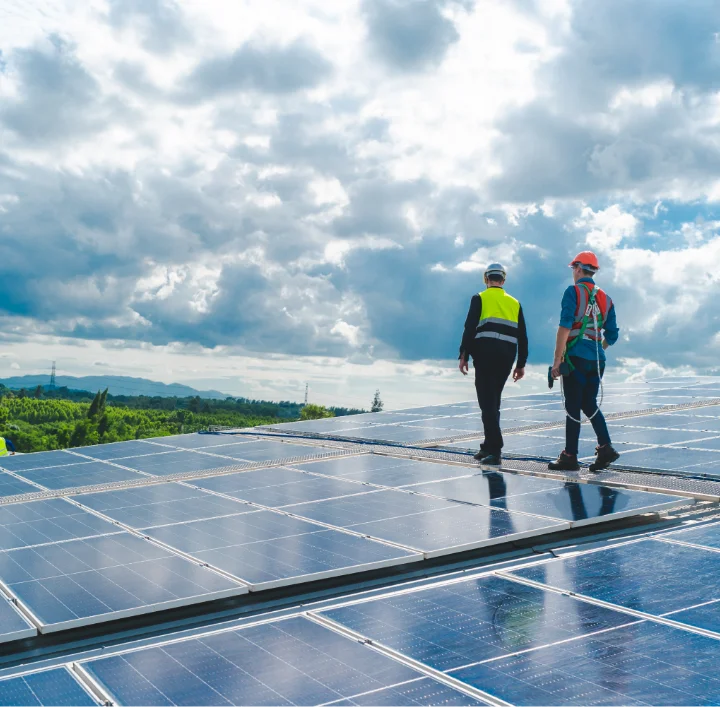 Two solar installers walking on mounted panels at a commercial agricultural site in Indiana
