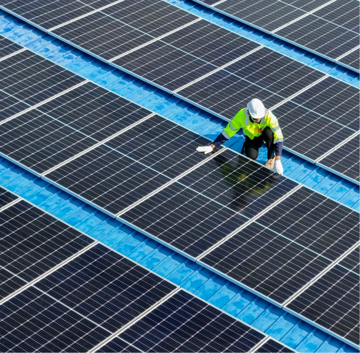 Technician installing rows of industrial and commercial solar panels at an Indiana facility