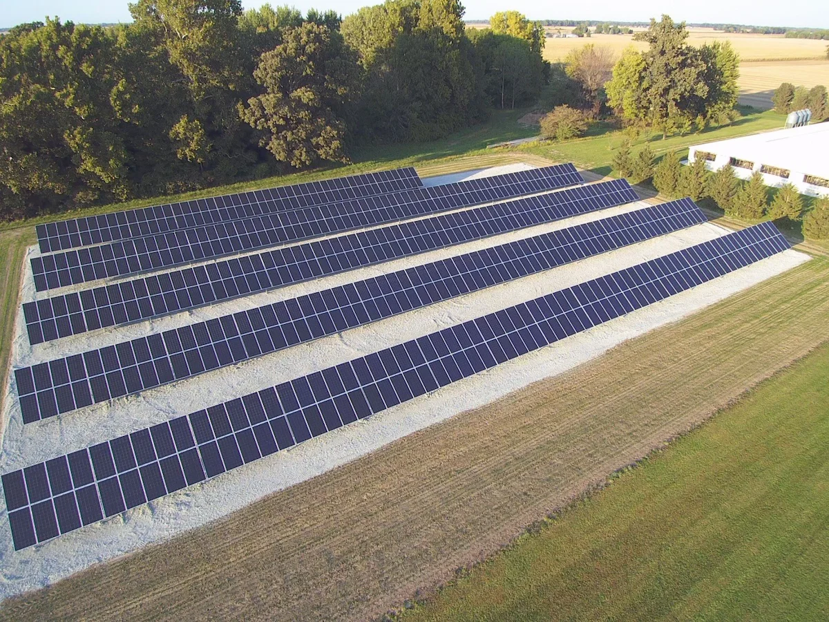 Agricultural solar panels installed in an open field on a sunny day in Indiana, generating renewable energy for farm operations