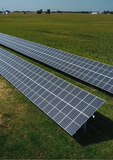 Solar panel array installed in lush green grass on a rural Indiana property