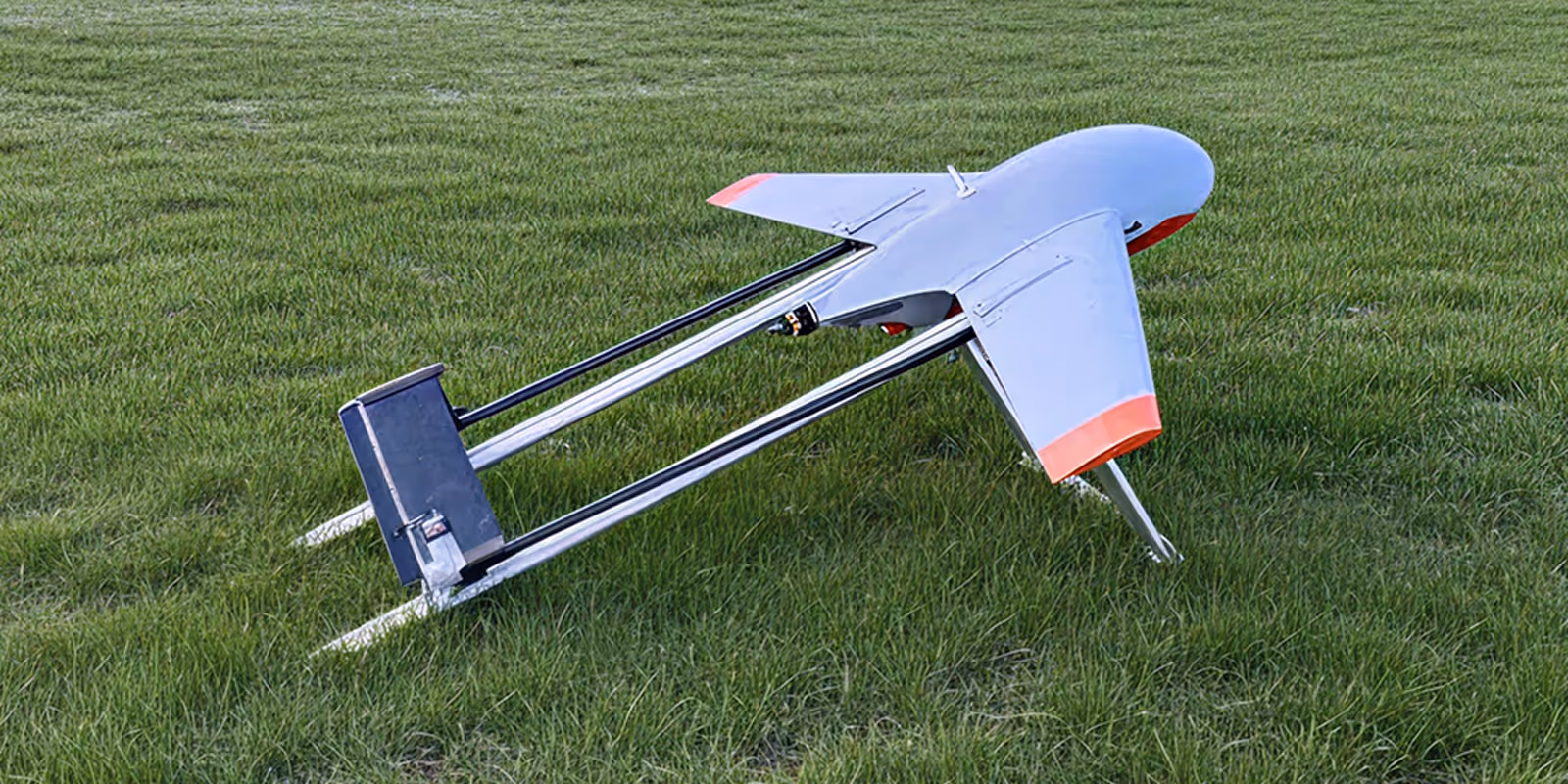 Quadcopter drone flying in a clear sky, angled with spinning propellers visible.
