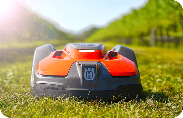 Husqvarna 550 EPOS robotic lawn mower on green grass in a sunny outdoor setting.