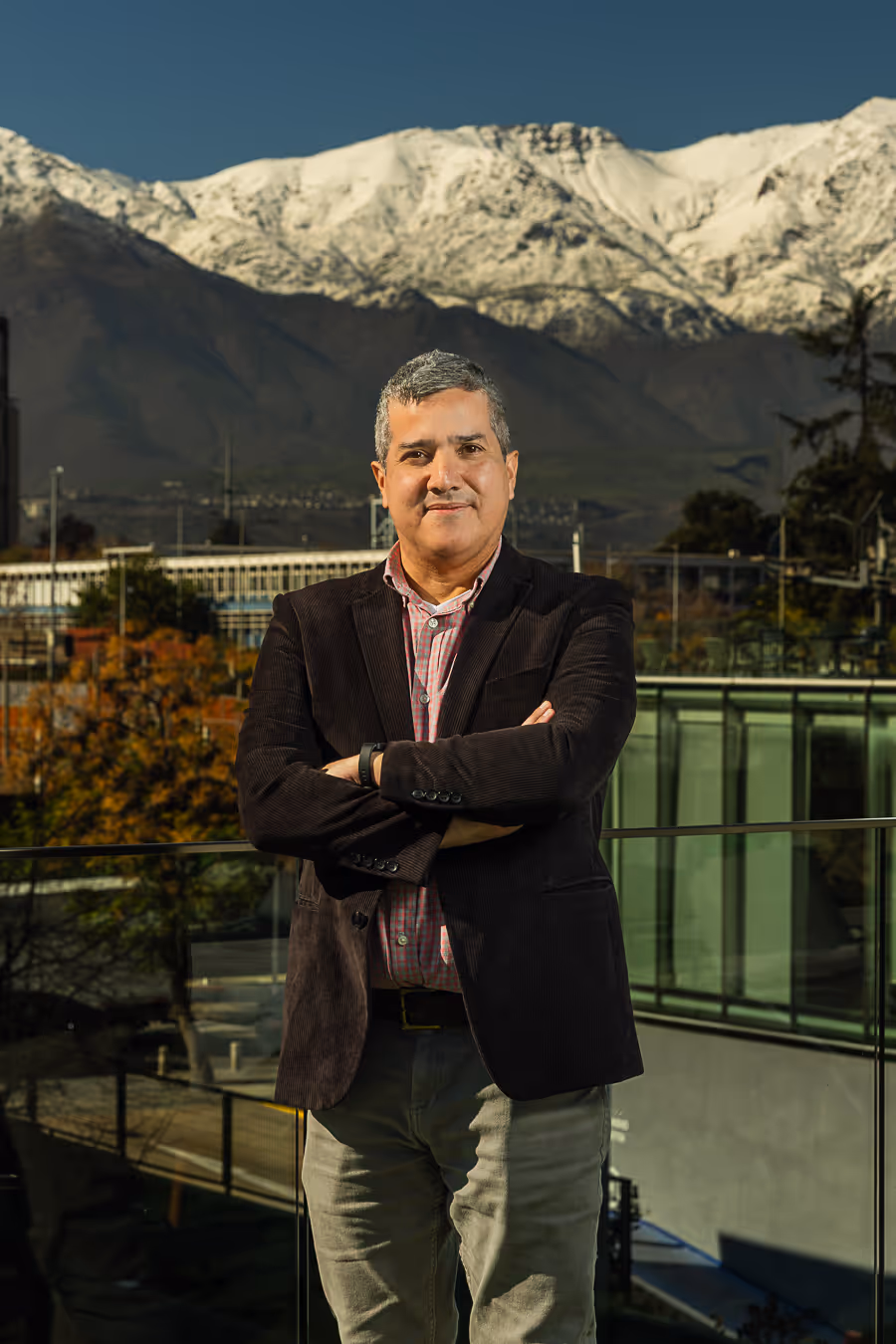 Retrato de Jorge Parra con fondo de ciudad y montañas