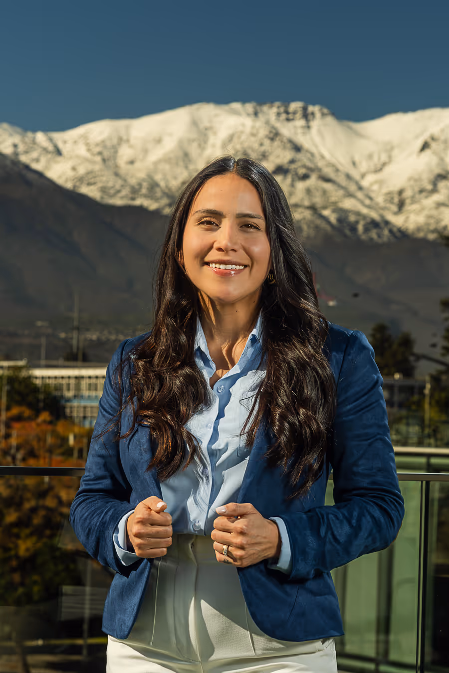 Retrato de Diana Vasquez con fondo de ciudad y montañas